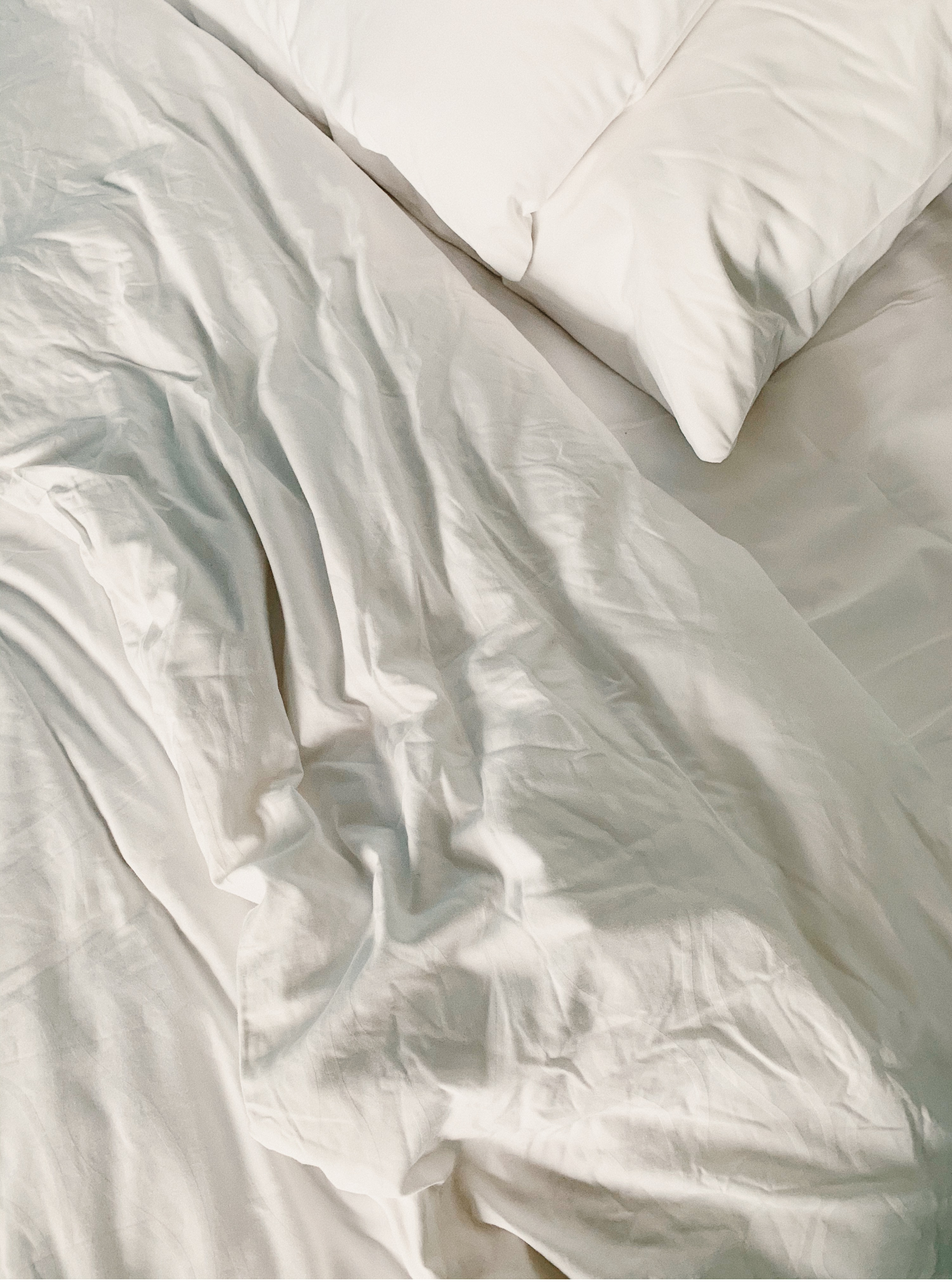 White sheets and comforter on bed with pillow