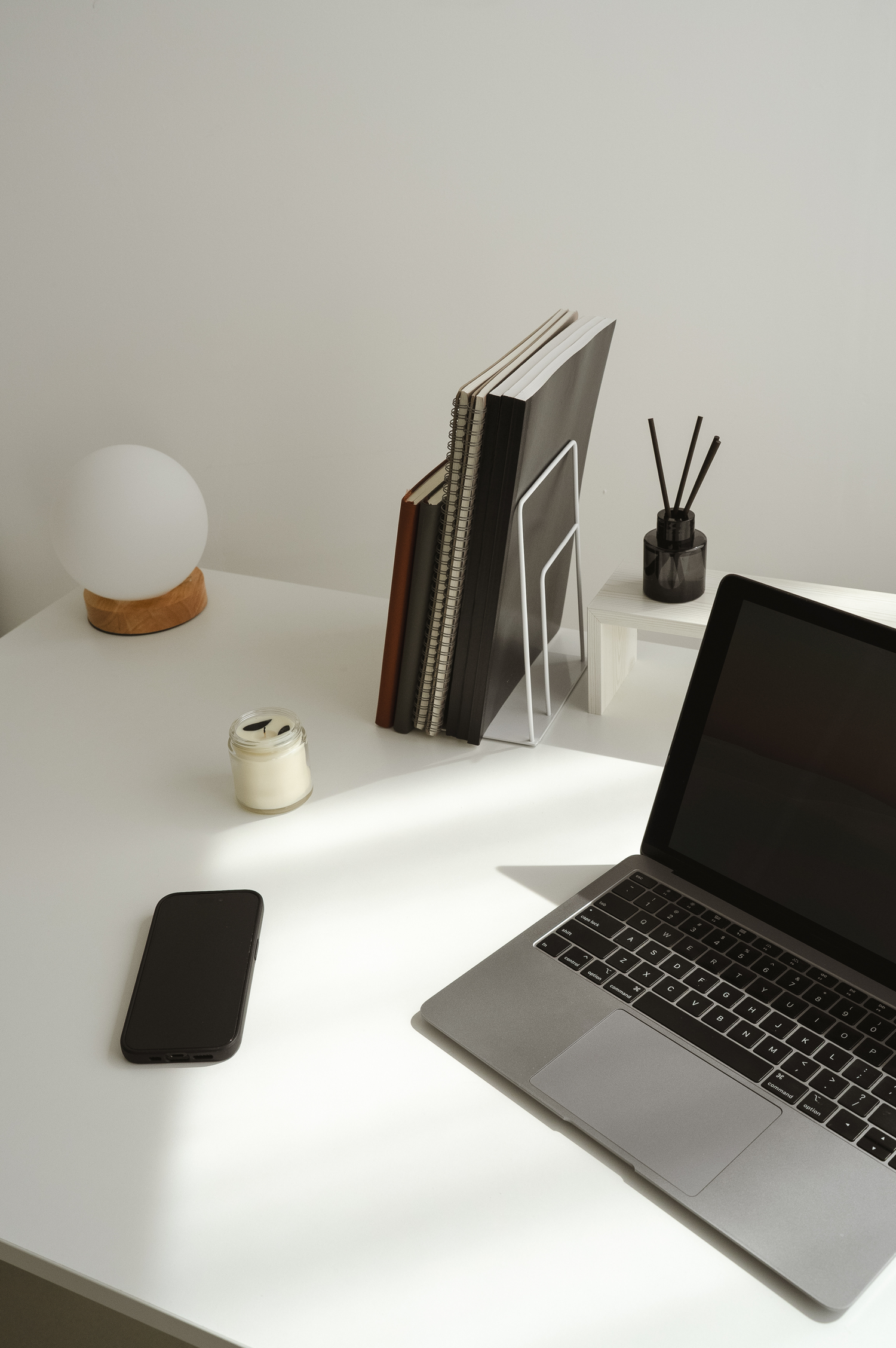 Laptop, iPhone, notebooks and lap on a white desk