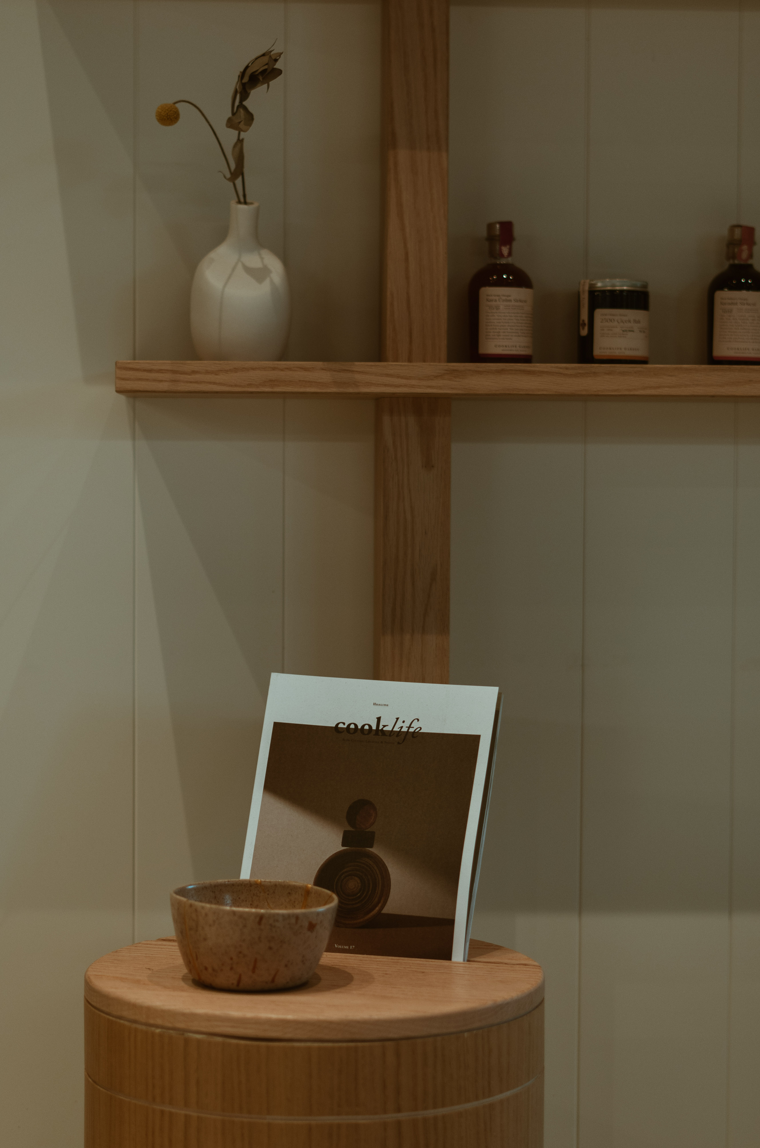 Wooden store shelf with product and display table with bowl and magazine